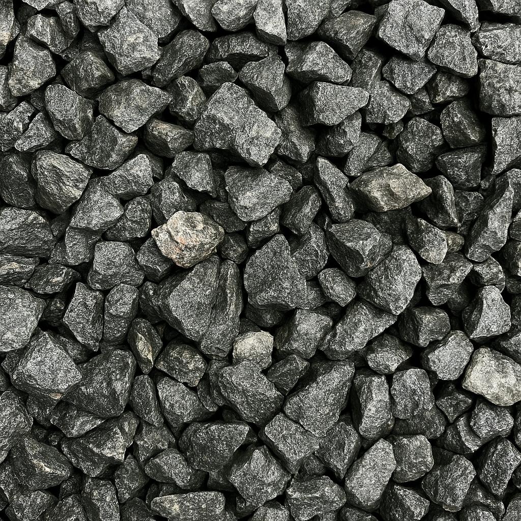A pile of dark gray, jagged gravel stones closely packed together, forming a textured background with a rough, uneven surface.