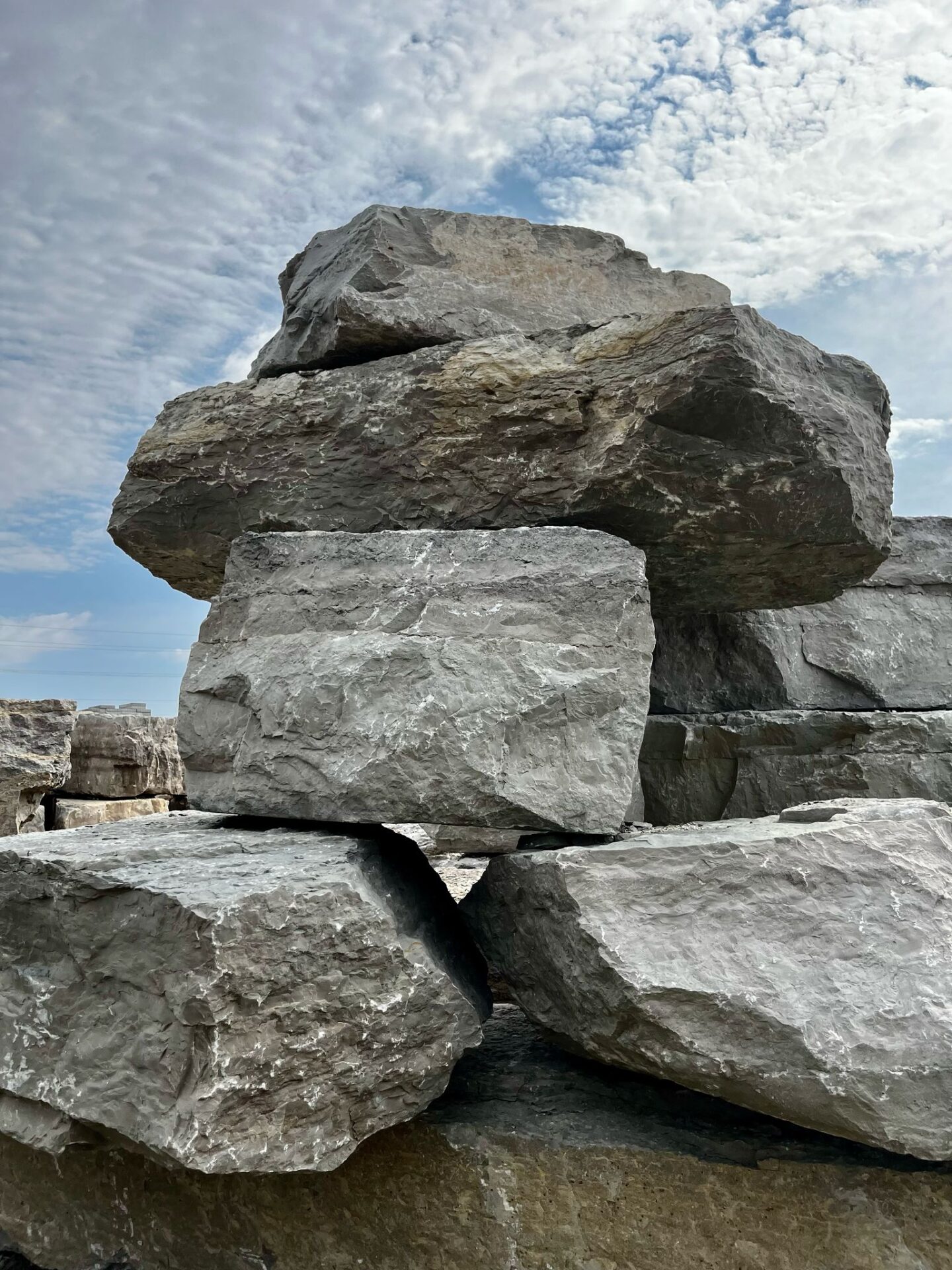 Large stacked gray rocks under a partly cloudy sky provide a natural, rugged landscape with no visible landmarks or structures.