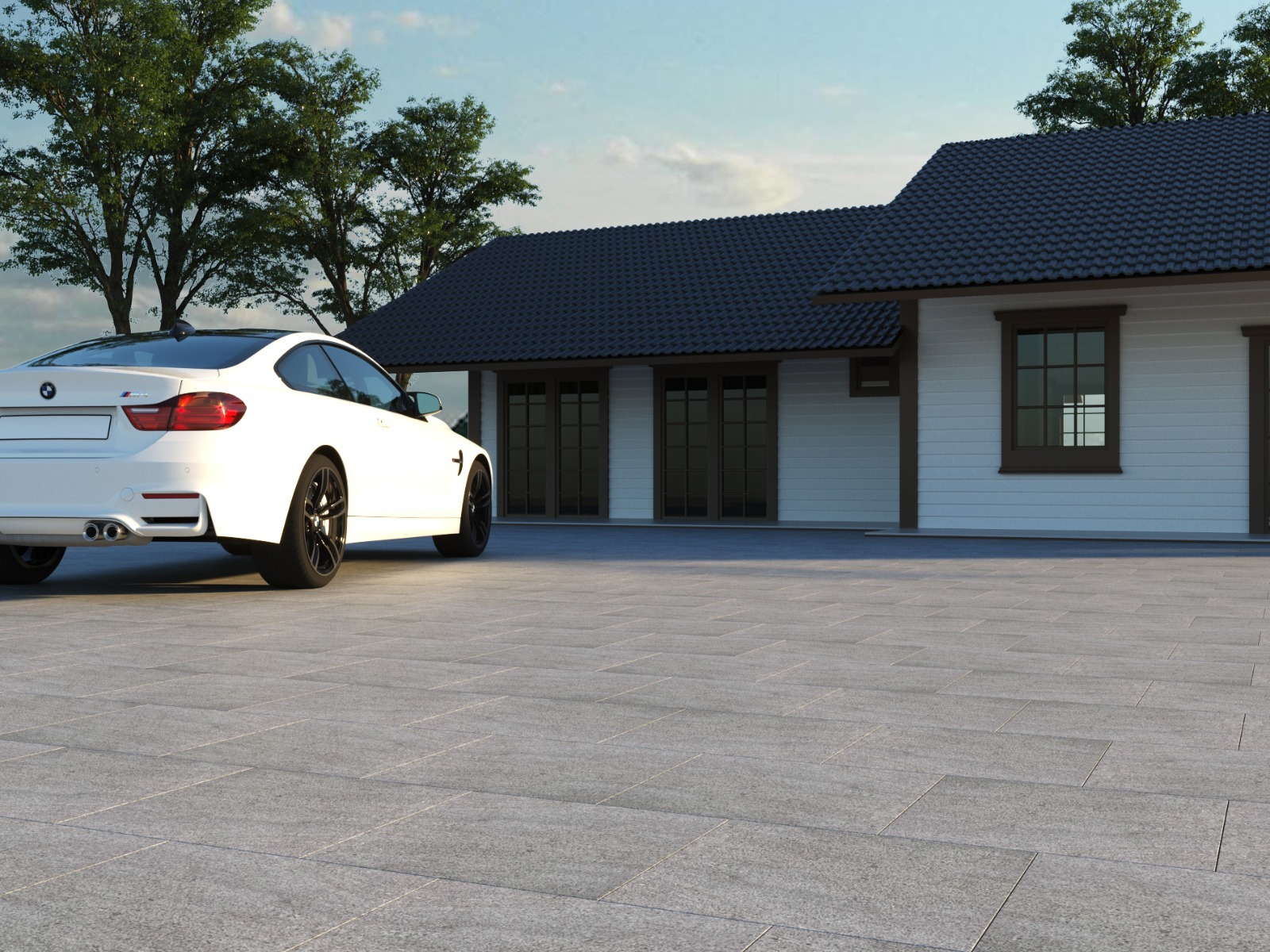 A white car parked on a paved driveway in front of a modern house with dark roof tiles, surrounded by trees.