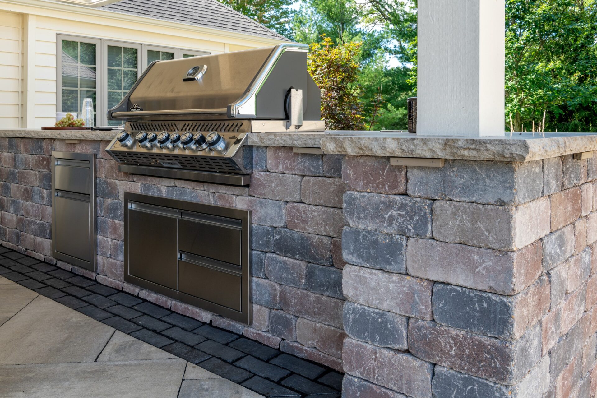 Stone outdoor kitchen island with built-in gas grill.