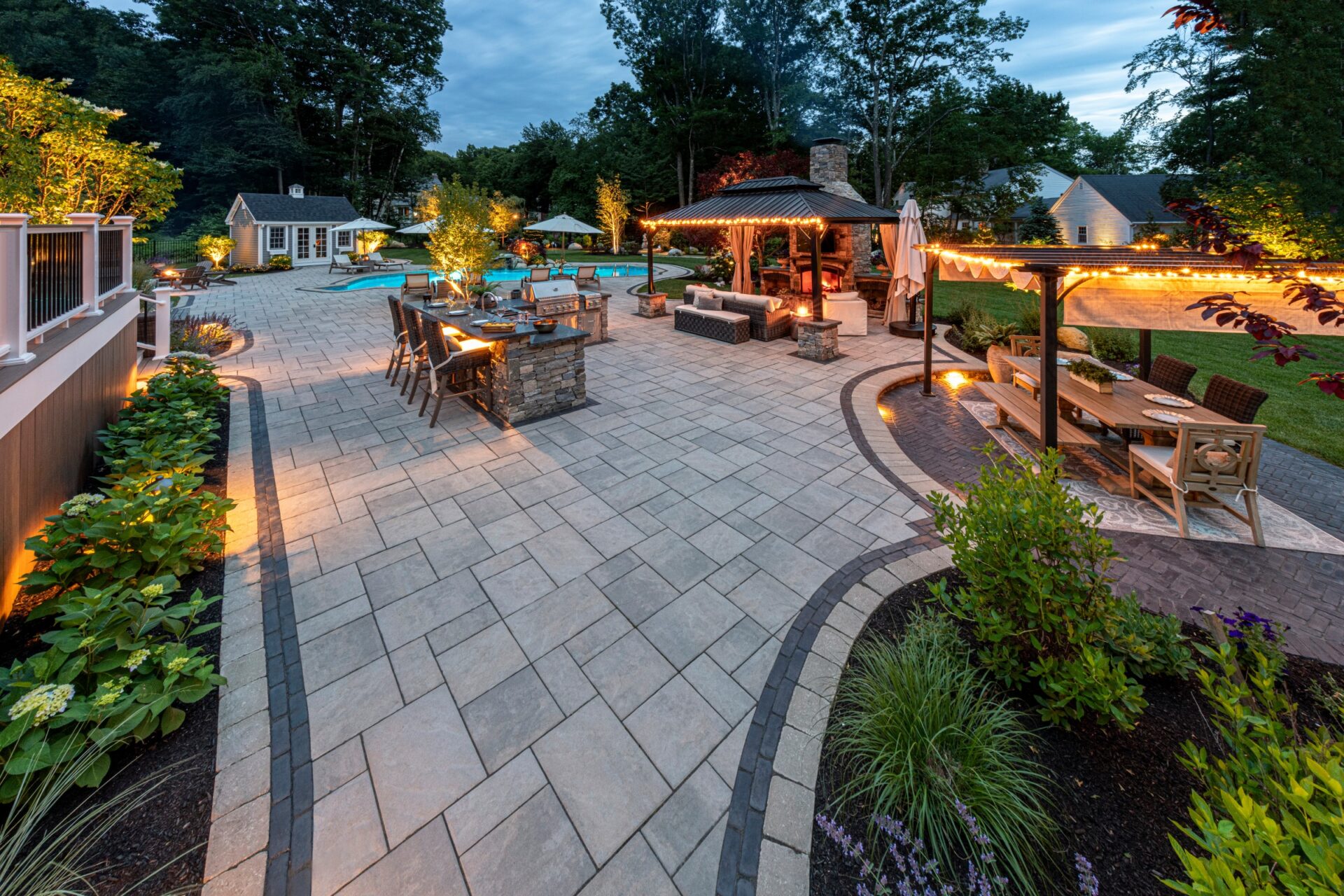 Patio with outdoor dining area illuminated by path and hardscape lighting.