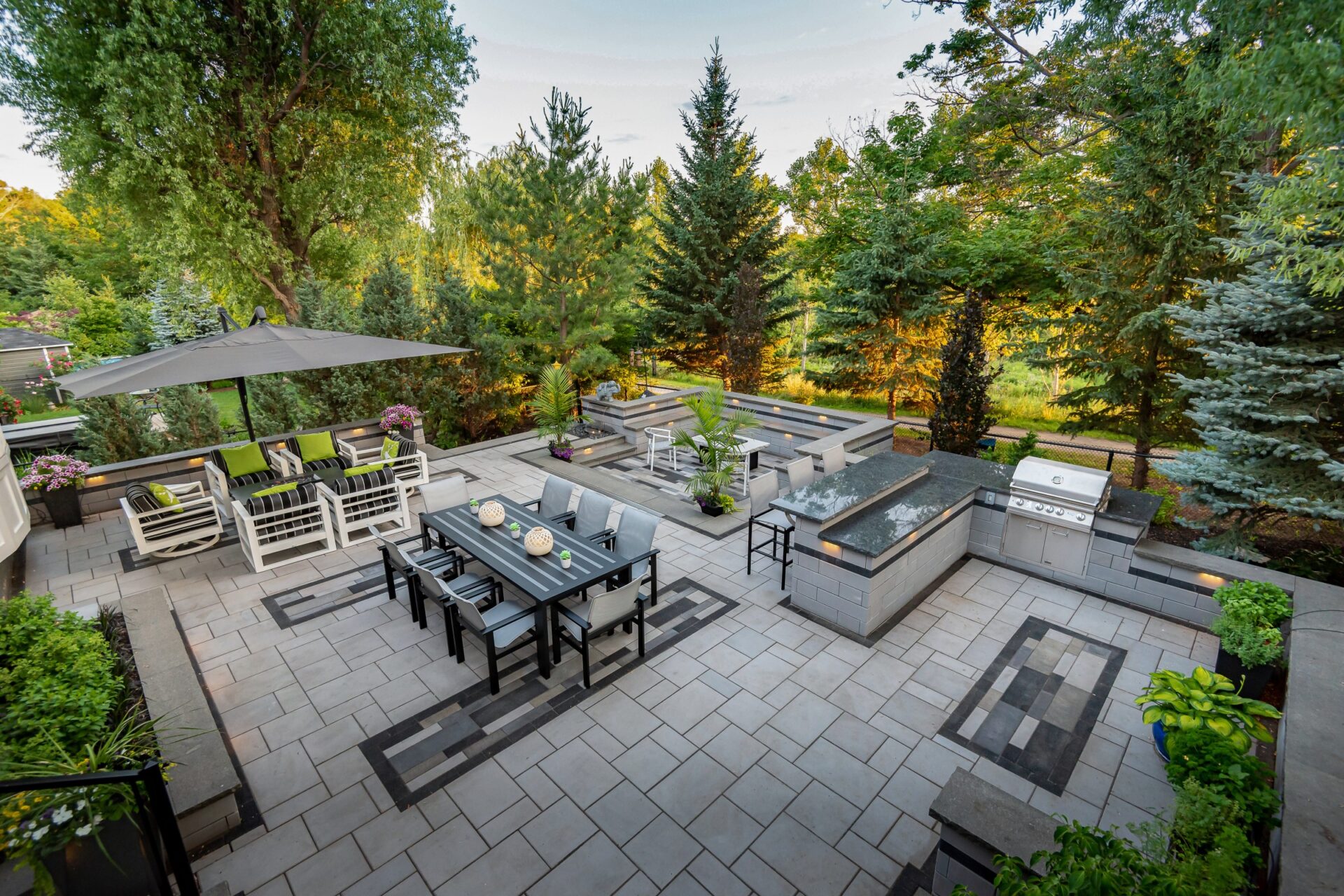 Large outdoor kitchen with forest view patio and grilling stations.