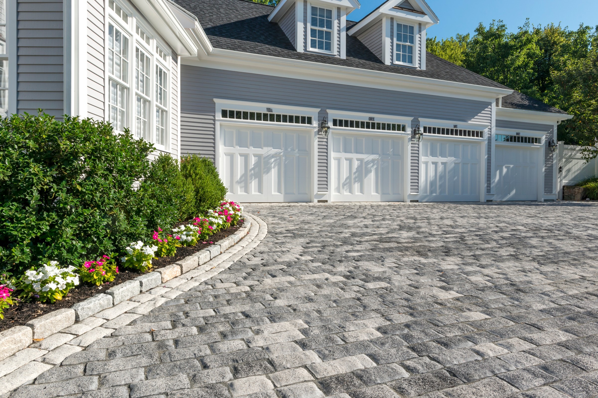 Driveway and front garden with cobblestone pavers.
