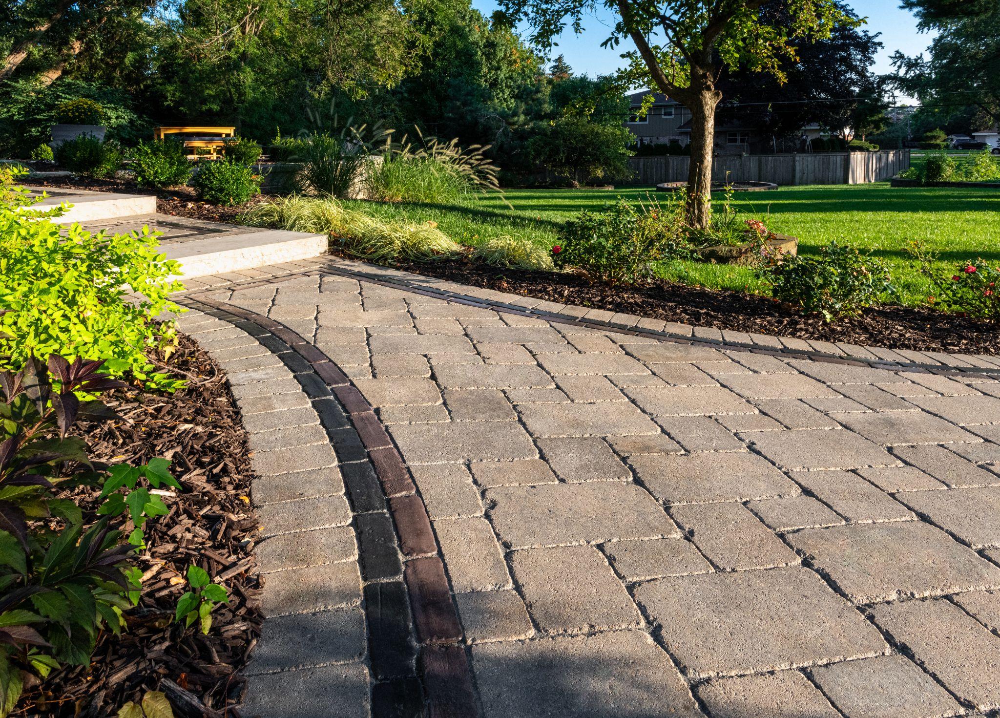 Curved paver walkway with mulch beds and lawn border