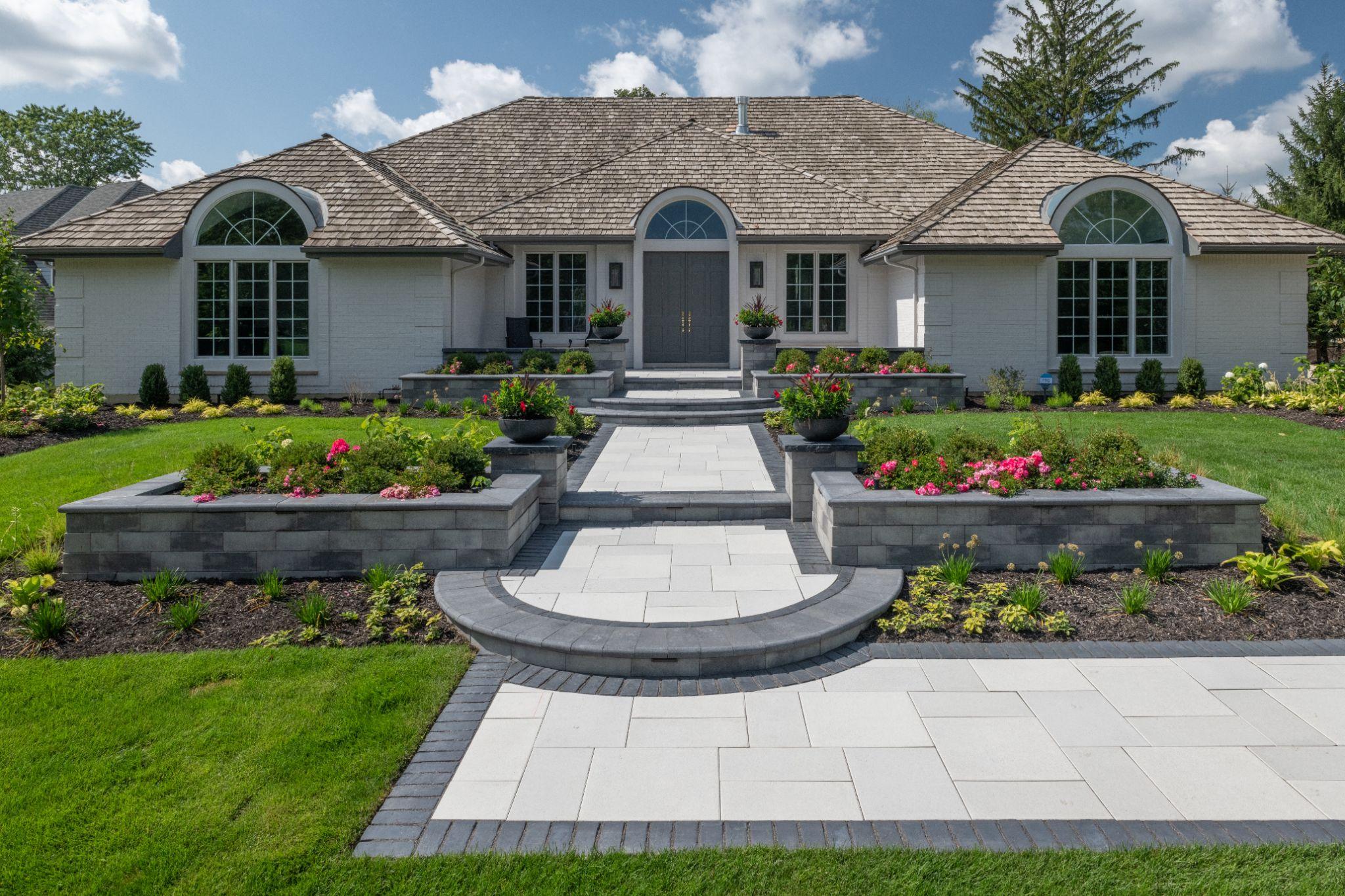 Front yard walkway with large pavers and raised garden beds