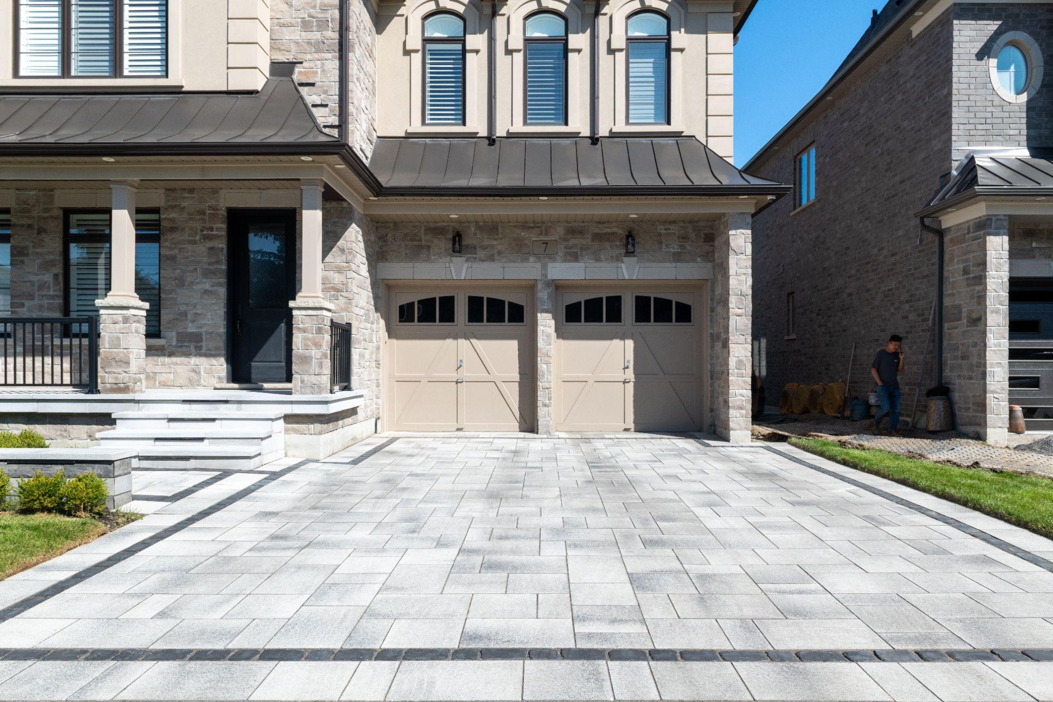 Interlocking paver driveway in front of stone home